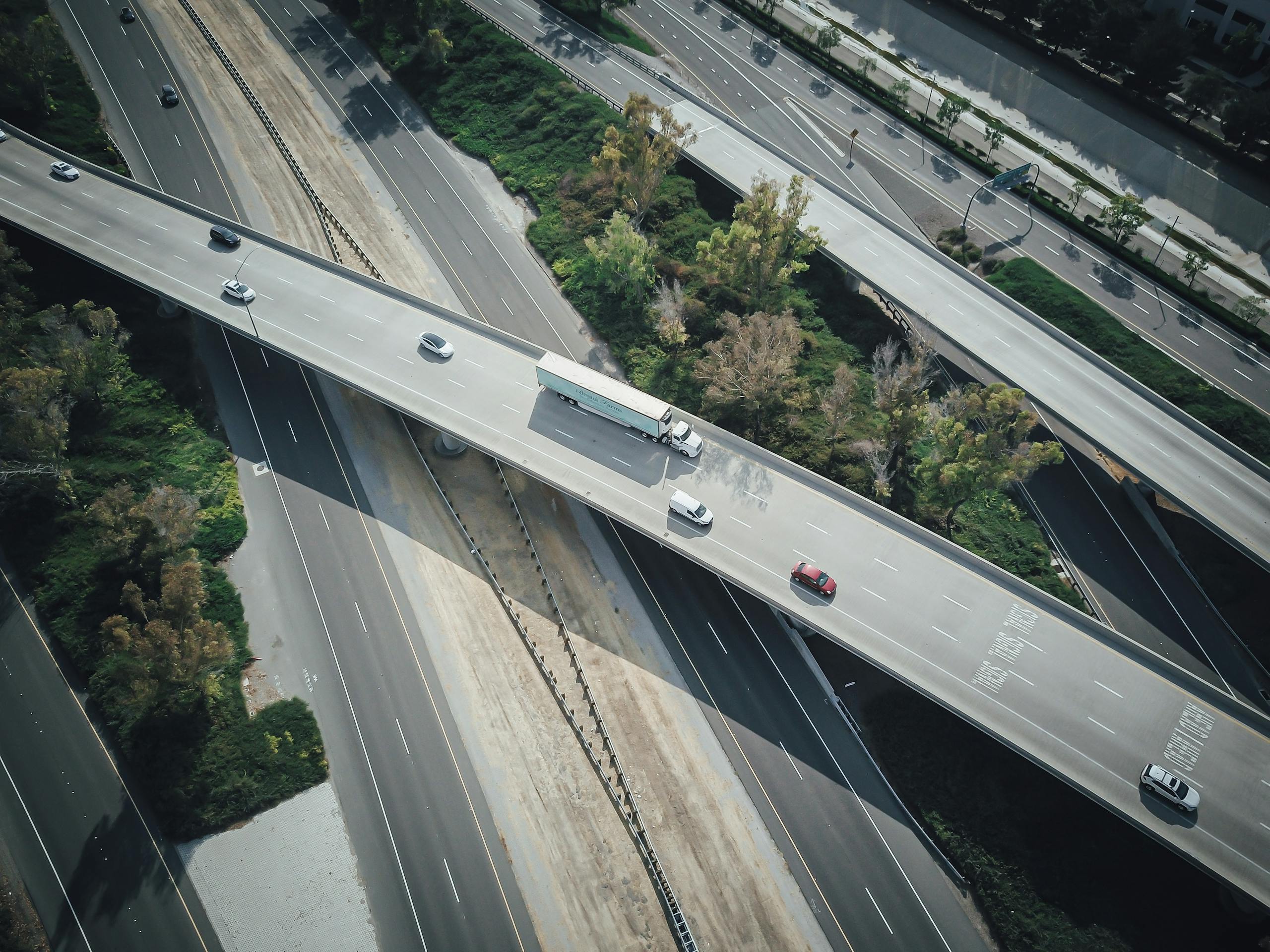 High-angle aerial shot of a highway intersection with various vehicles in motion.